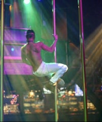 a man doing a pole dance in a club